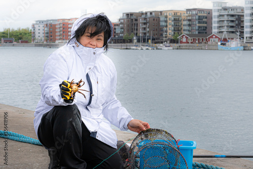 A newly catched crab showed by an asian woman photo