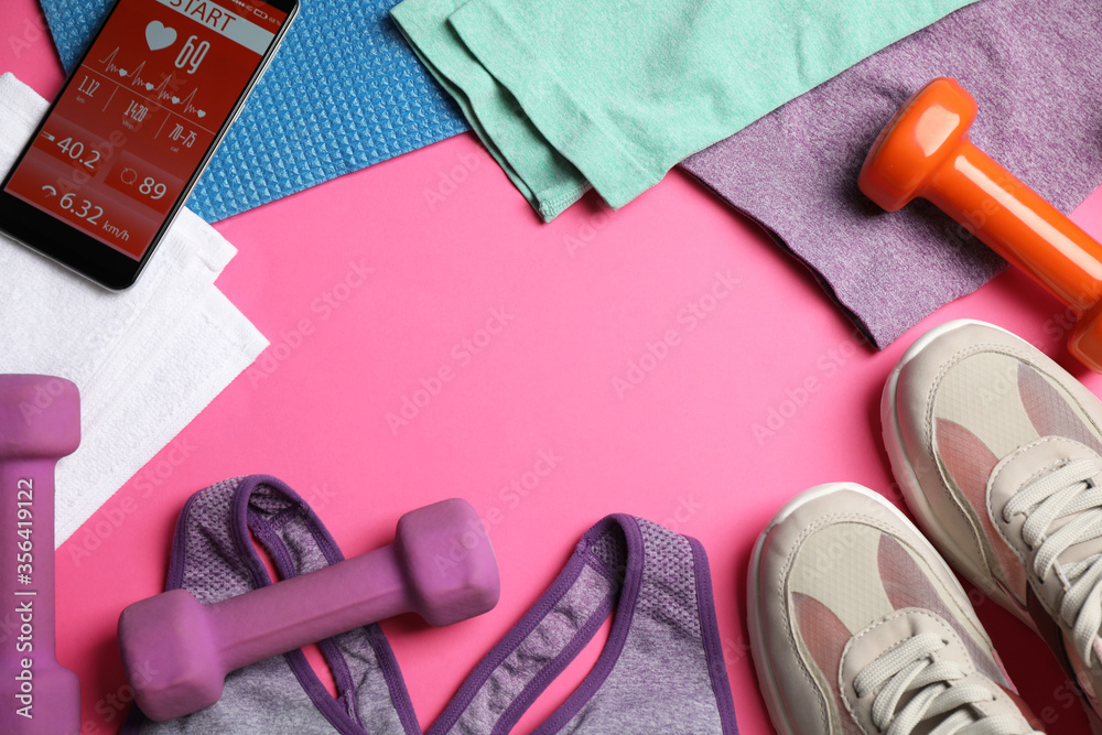 Frame made with fitness equipment and smartphone on pink background, flat lay. Space for text Frame made with fitness equipment and smartphone on pink background, flat lay. Space for text