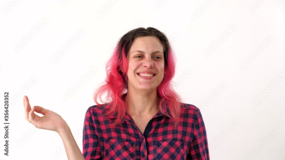 Portrait of a laughing young woman with pink hair in a plaid shirt. Disheveled girl laughs joyfully. Smile with white teeth. Emotional pretty girl. Portraits of diverse people. Portrait of a laughing young woman with pink hair in a plaid shirt. Disheveled girl laughs joyfully. Smile with white teeth. Emotional pretty girl. Portraits of diverse people.