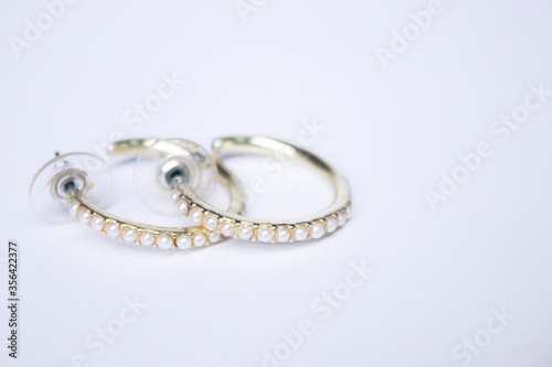 Round gold earrings with white stones. jewelry and accessories concept. Isolated, copy space. Macro Shot. High quality photo