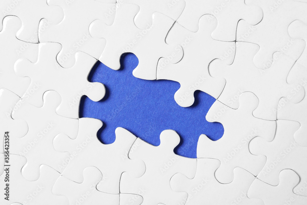 Blank white puzzle with missing pieces on blue background, top view Blank white puzzle with missing pieces on blue background, top view