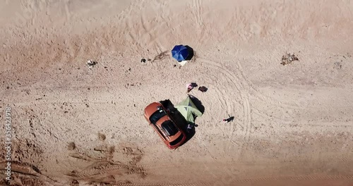 Top down view of solo camping on tropical sandy beach. Zoom out fly.