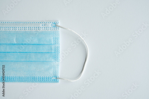 Face medical mask on a gray background. Disposable 3-ply medical mask to cover the mouth and nose to prevent coronavirus. Coronavirus quarantine. Antivirus medical mask for protection covid-19.