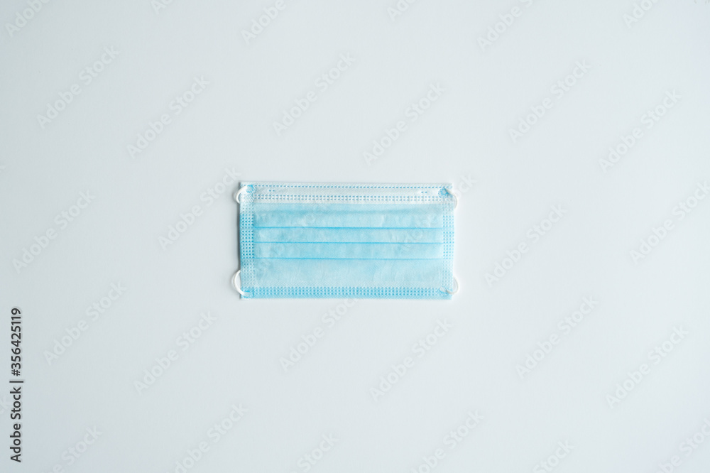 Face medical mask on a gray background. Disposable 3-ply medical mask to cover the mouth and nose to prevent coronavirus. Coronavirus quarantine. Antivirus medical mask for protection covid-19. Face medical mask on a gray background. Disposable 3-ply medical mask to cover the mouth and nose to prevent coronavirus. Coronavirus quarantine. Antivirus medical mask for protection covid-19.