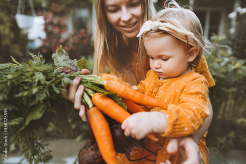 Fotografia Mother and child daughter with organic vegetables healthy food family lifestyle