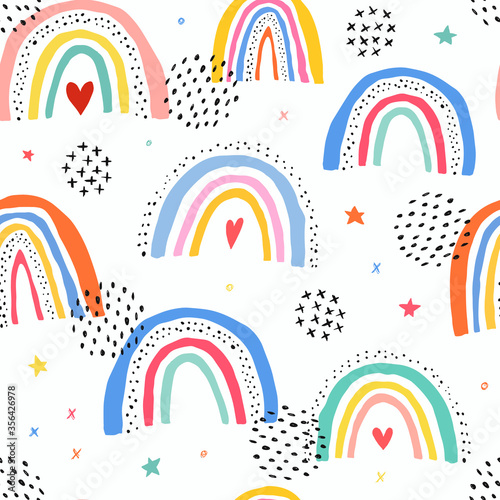 cute seamless pattern with rainbows and graphic decorative elements for baby textile and fabric prints, wallpaper, scrapbooking, bedding, wrapping paper, etc.