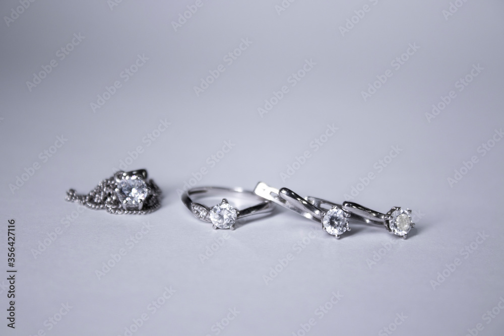 Expensive set of silver women's jewelry - ring, pendant and earrings. Isolated, copy space. Macro Shot. High quality photo
