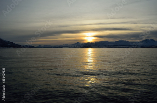 beautiful sunset over snowy mountain and fjord © Arcticphotoworks
