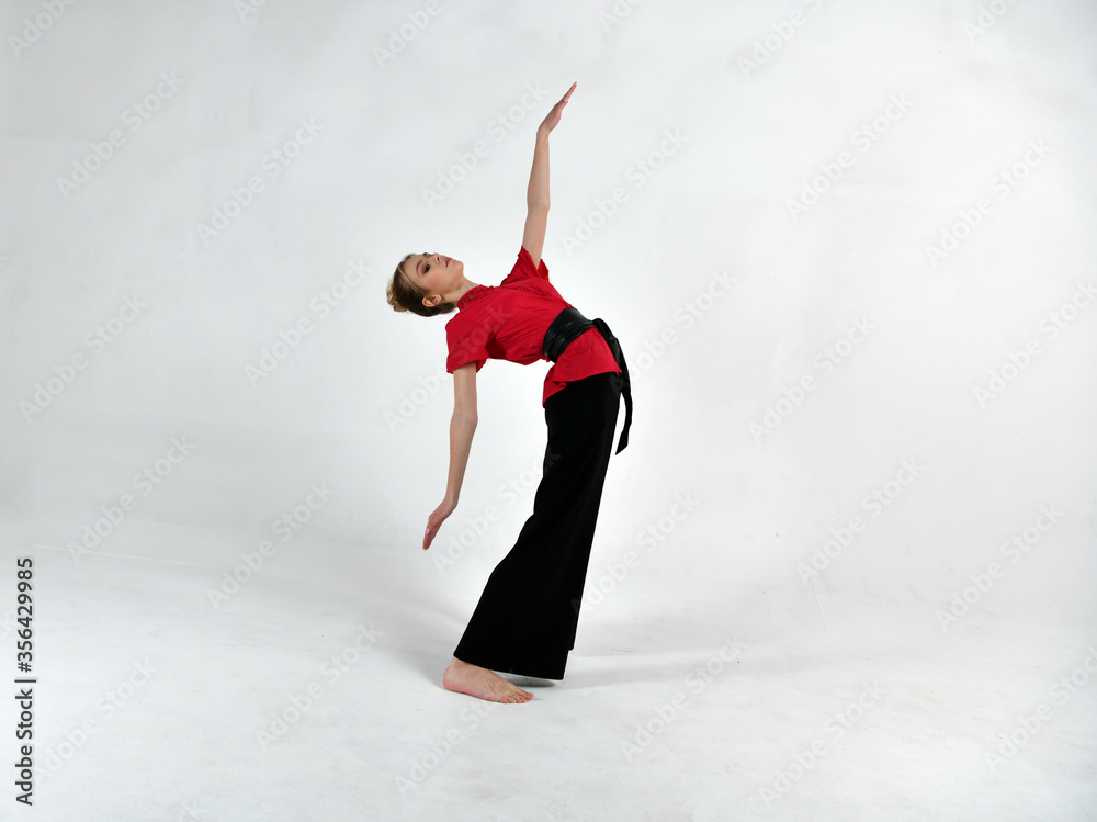 beautiful girl in a red-black suit does exercises in the style of martial arts beautiful girl in a red-black suit does exercises in the style of martial arts