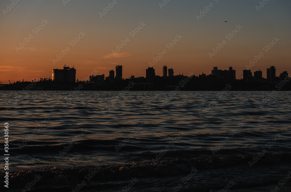 An evening by the beach: A silhouette view of buildings by the seashore in Mumbai City