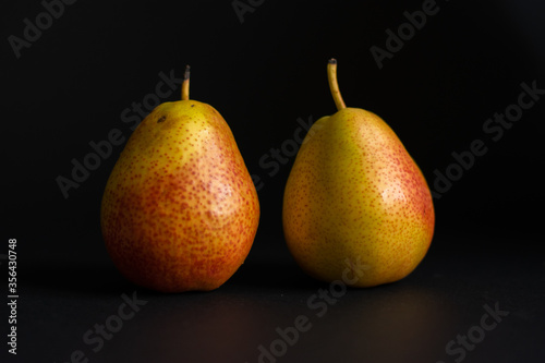 Two pears over black background.