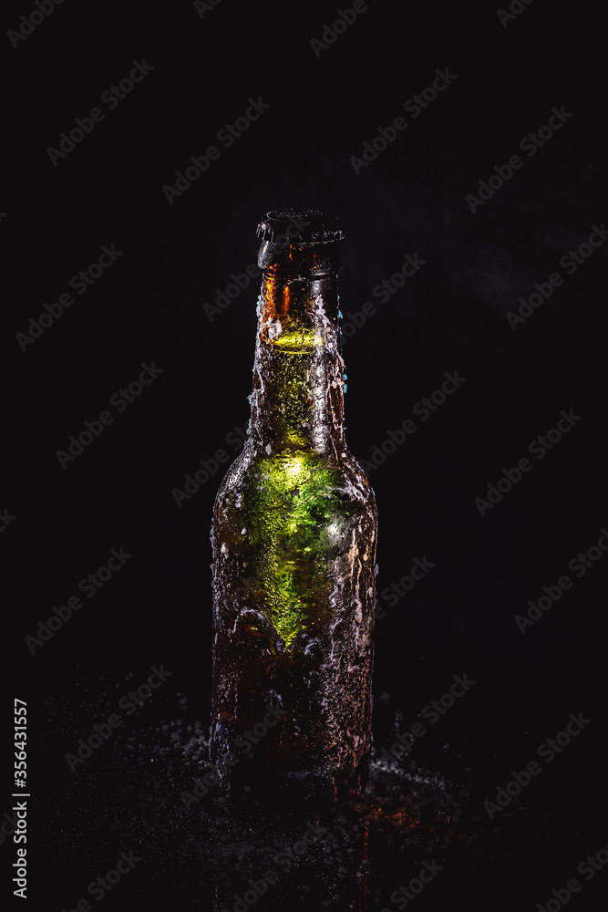 green beer bottle with frost on a black background green beer bottle with frost on a black background