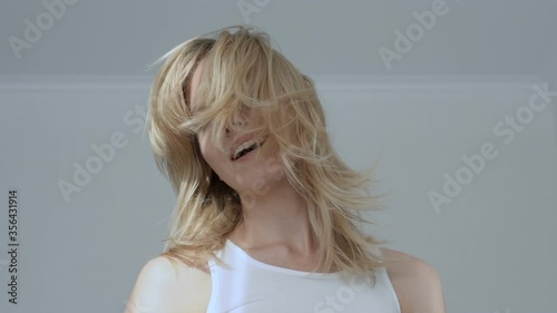 Excited girl moving sensually, waving hair and smiling happily, satisfaction
