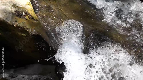 Super slow motion of a torrent flowing in cascade over a rock