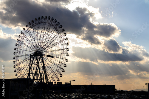 big wheel in city with cloudy sky.