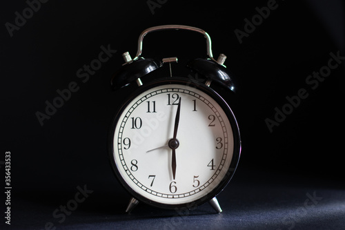 Alarm clock on a black background.