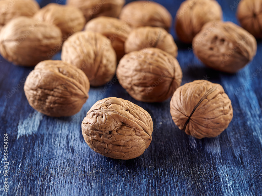 Walnuts lie on a colored wooden background.Nuts are good for your health.Vegan Walnuts lie on a colored wooden background.Nuts are good for your health.Vegan