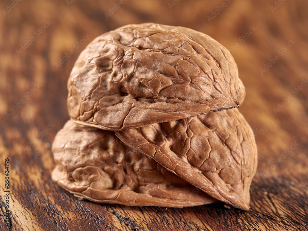 Fototapeta premium Walnuts lie on a colored wooden background.Nuts are good for your health.Vegan
