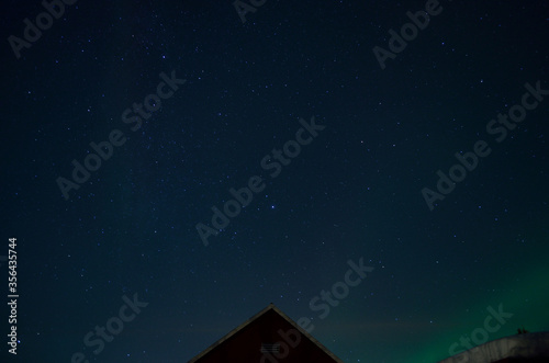 aurora borealis northern light over red barn roof
