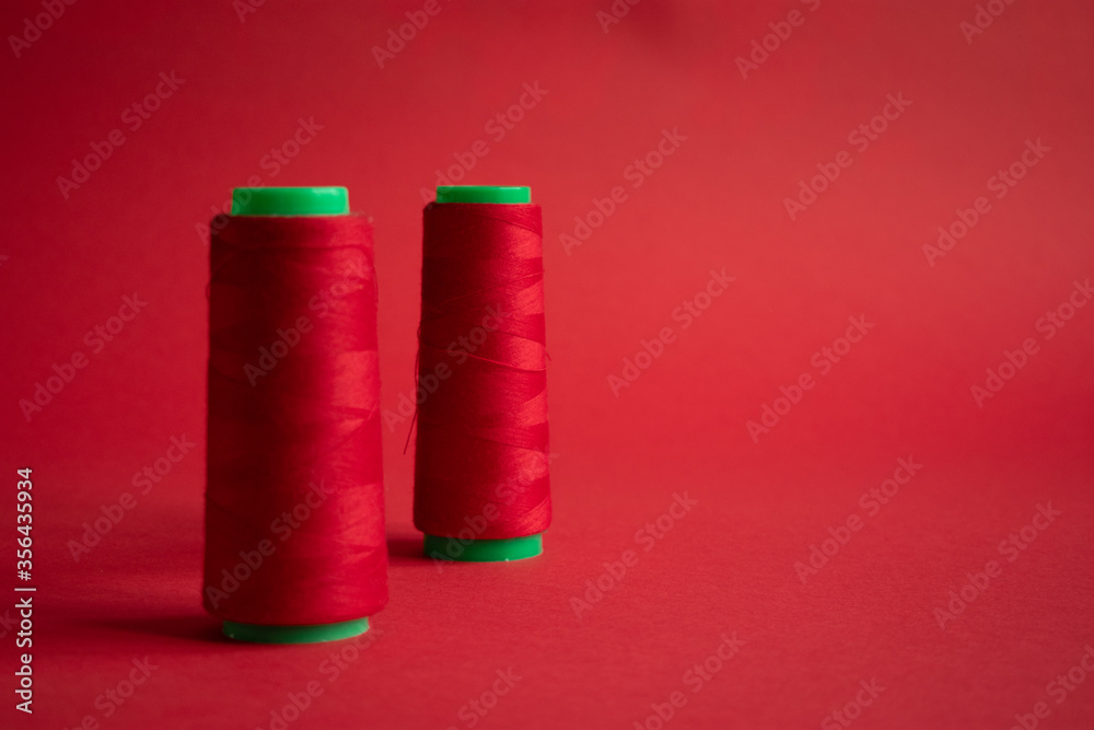 Bobbins on red background. Sew and tailoring concept, sewing tools, needlework. Bobbins on red background. Sew and tailoring concept, sewing tools, needlework.