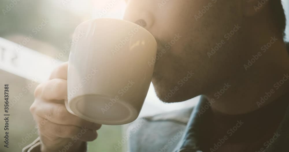 Smart young businessman drinking coffee in a sun flare
