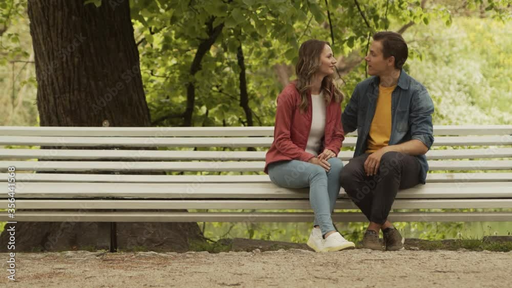 Young, happy, loving couple having date in the park. Relations, friendship and love concept. Young, happy, loving couple having date in the park. Relations, friendship and love concept.