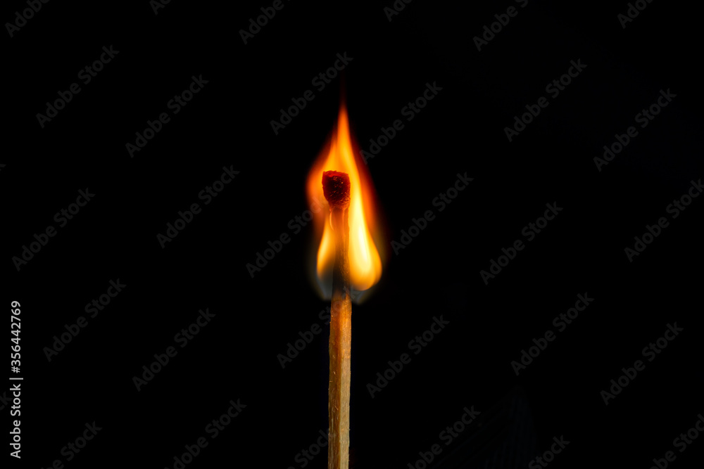 Low key, burning matchstick on black background, macro Low key, burning matchstick on black background, macro