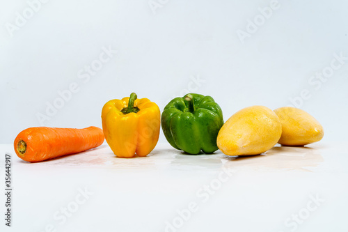 Mix Fruits for Healthy Eating, Carrot, Bell Pepper and Mangos with Water Drop on Isolated White Background.