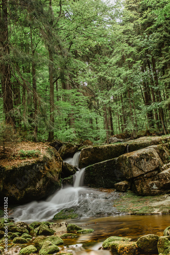 Waterfall photo.Long exposure photo of beautiful Pekelny waterfall,Jizerske mountains,Czech. Motion blurr water in a mountain creek in deep forest. Hiking in a nature reserve.Fresh clean nature scene