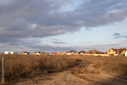 Canvas Print Dirt roadway to new cottage houses. Outland road view