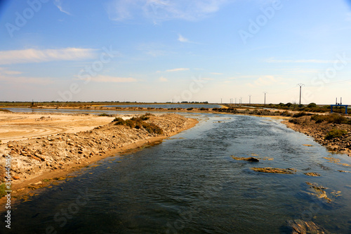 Shallow river in between dry areas in the Camargue, France on a warm sunny day