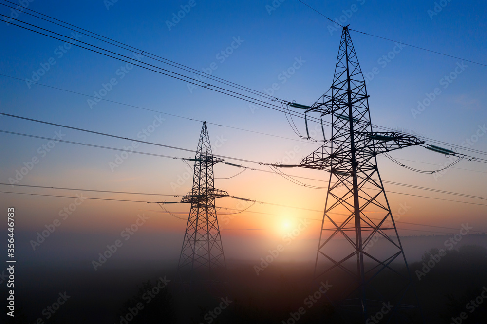 Energy Distribution Network, transmission line pylon, at sunset.