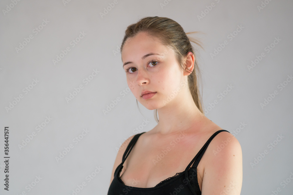 Fototapeta premium Attractive young woman posing in studio against a grey background