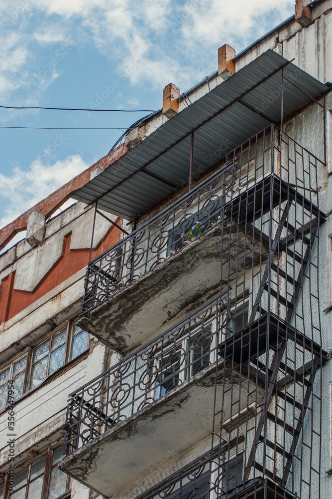 A fireman between floors is attached to the balconies. Old multistory building of the last century in the Russian city.
A fireman between floors is attached to the balconies. Old multistory building of the last century in the Russian city.
