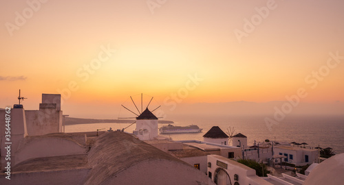 Windmill and cruise ship at sunset in Oia  Santorini Island  Cyclades  Greece 