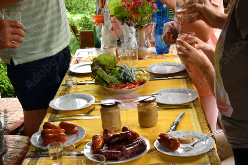Table with toasted sausage  vegetables and mustard typical food in the village