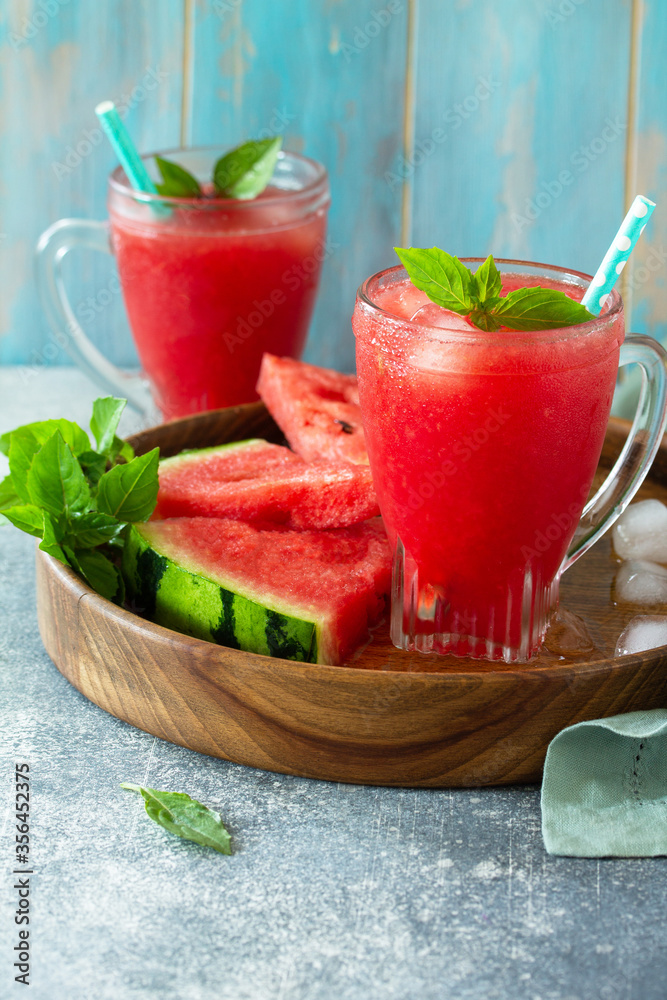 Cold Watermelon Smoothie. Summer Watermelon drink and slices of watermelon on a light stone table. Copy space. Cold Watermelon Smoothie. Summer Watermelon drink and slices of watermelon on a light stone table. Copy space.