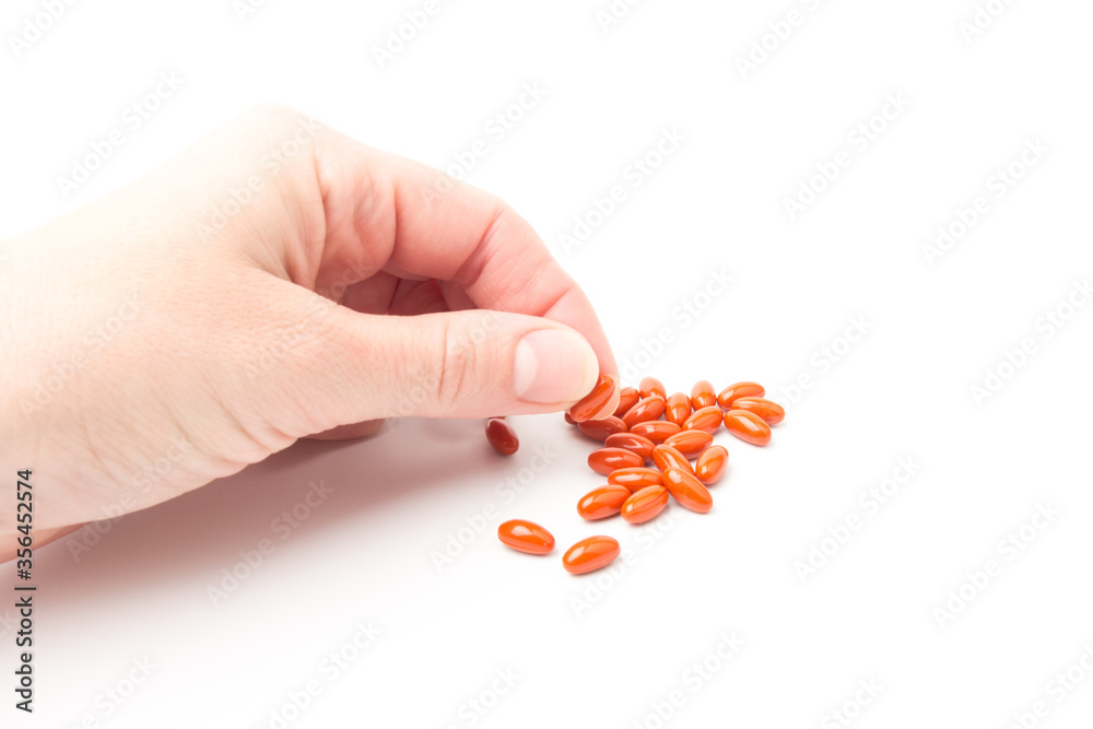 Coenzyme q10 supplement capsules in hand close-up on white background Coenzyme q10 supplement capsules in hand close-up on white background