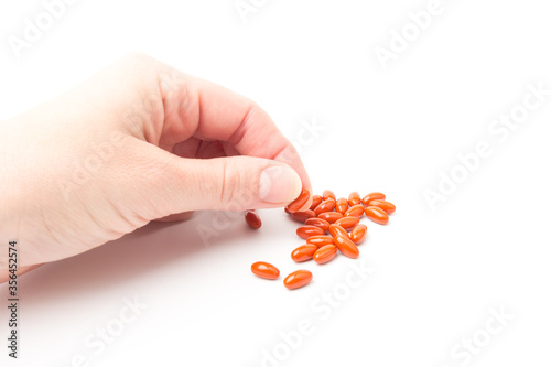 Coenzyme q10 supplement capsules in hand close-up on  white background
