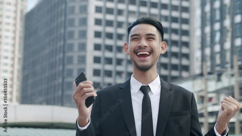 Handsome businessman using smartphone happy and successful in a city Handsome businessman using smartphone happy and successful in a city