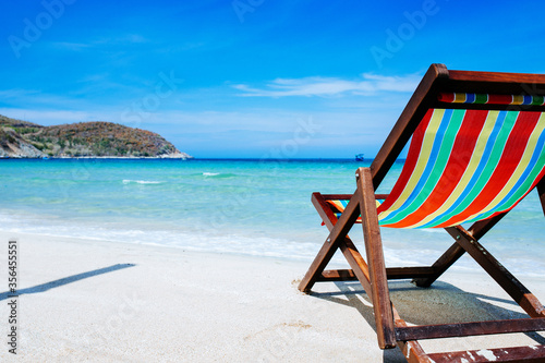 Beach chairs on a sandy beach by the ocean  the concept of relaxation  traveling on a tropical island  relaxation with beautiful views of the bruise sea and blue sky