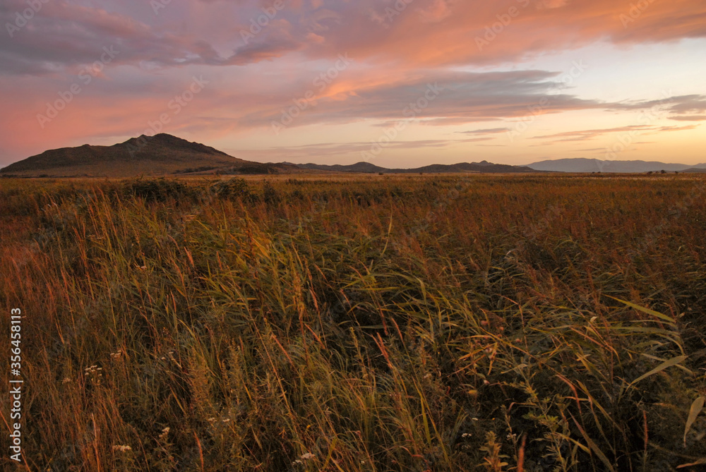 Sunset steppe landscape. Outskirts of Khasan town. Primorsky Krai (Primorye), Far East, Russia.