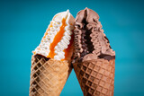 Two ice creams in cones leaning together