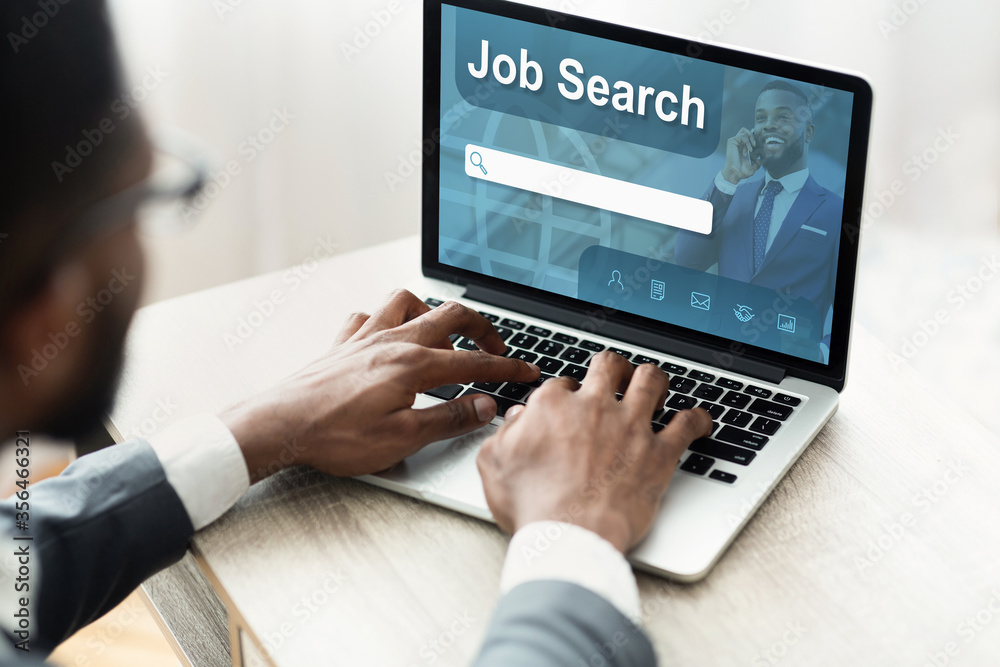 Black man using laptop with job search engine on screen Black man using laptop with job search engine on screen