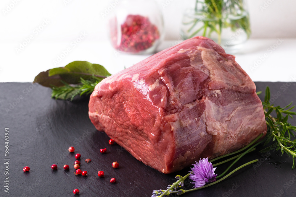 Food concept organic raw Round beefs steak on black slate stone plate with copy space Food concept organic raw Round beefs steak on black slate stone plate with copy space