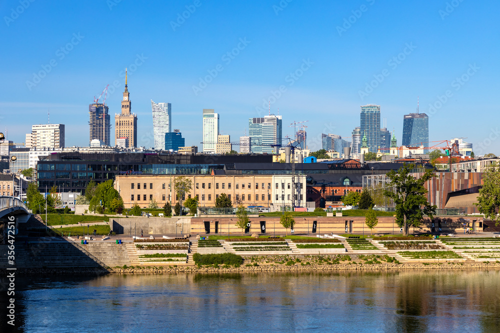 Panoramic view of Srodmiescie city center quarter and Powisle district at Wybrzeze Kosciuszkowskie embankment over Vistula river in Warsaw, Poland