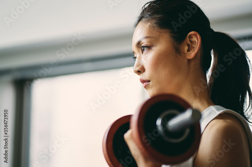 ダンベルトレーニングをする日本人女性