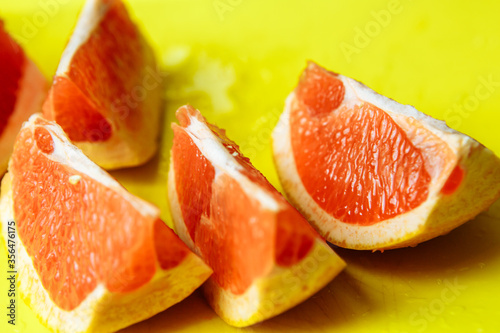 slices of juicy red grapefruit on a bright yellow board