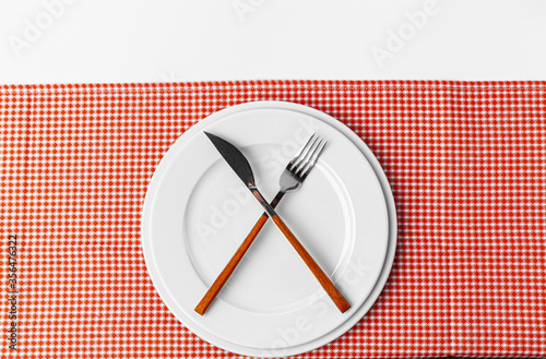 Fork, knife and plate on towel. Isolated on white background.