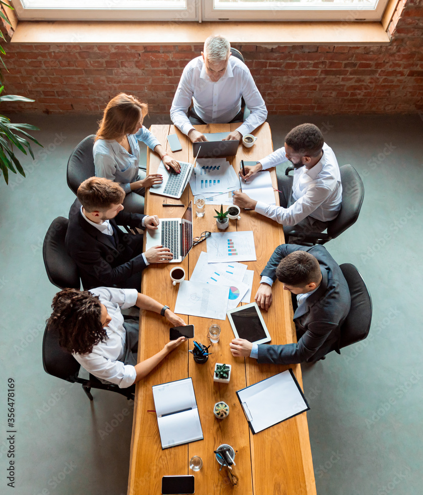 Business Colleagues Working Using Gadgets Sitting In Modern Office, Above-View Business Colleagues Working Using Gadgets Sitting In Modern Office, Above-View